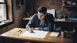 A strategist sketching a customer-journey diagram on paper in a Brooklyn studio