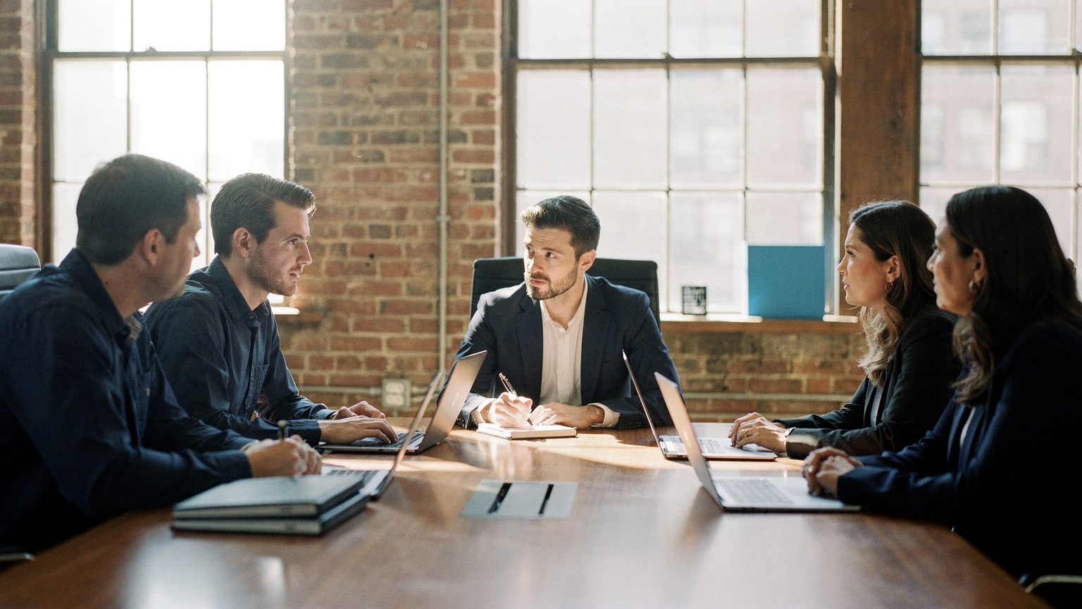 Technical buyers interviewing a Magento agency team across a table in a sunlit Brooklyn conference room