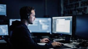 A security engineer reviewing Magento checkout integrity on a monitor in a Brooklyn operations room