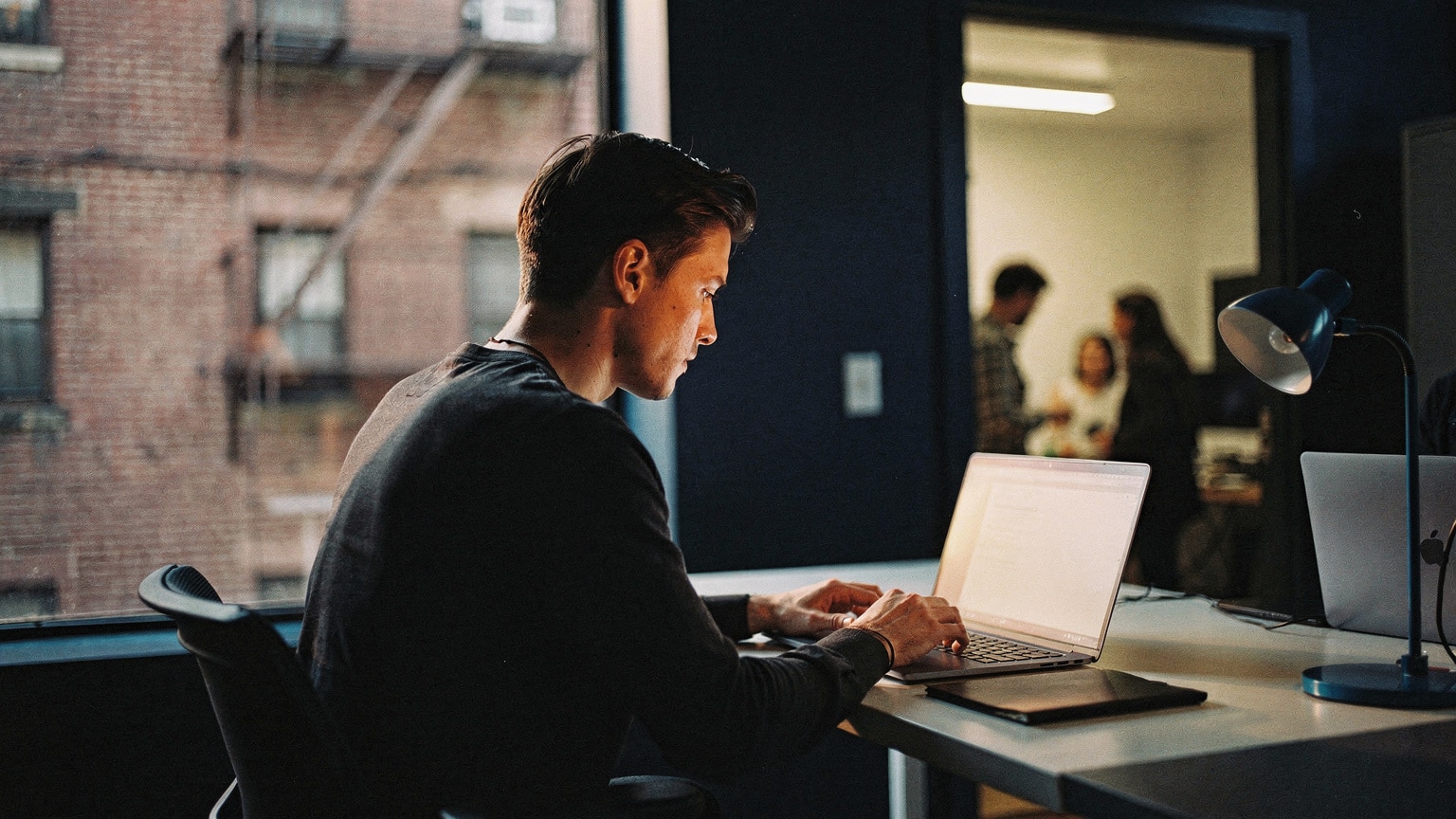 A solo developer working at a home office contrasted with a team workspace, a Magento staffing choice