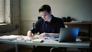 A catalog manager organizing detailed product information at a desk in a Brooklyn studio