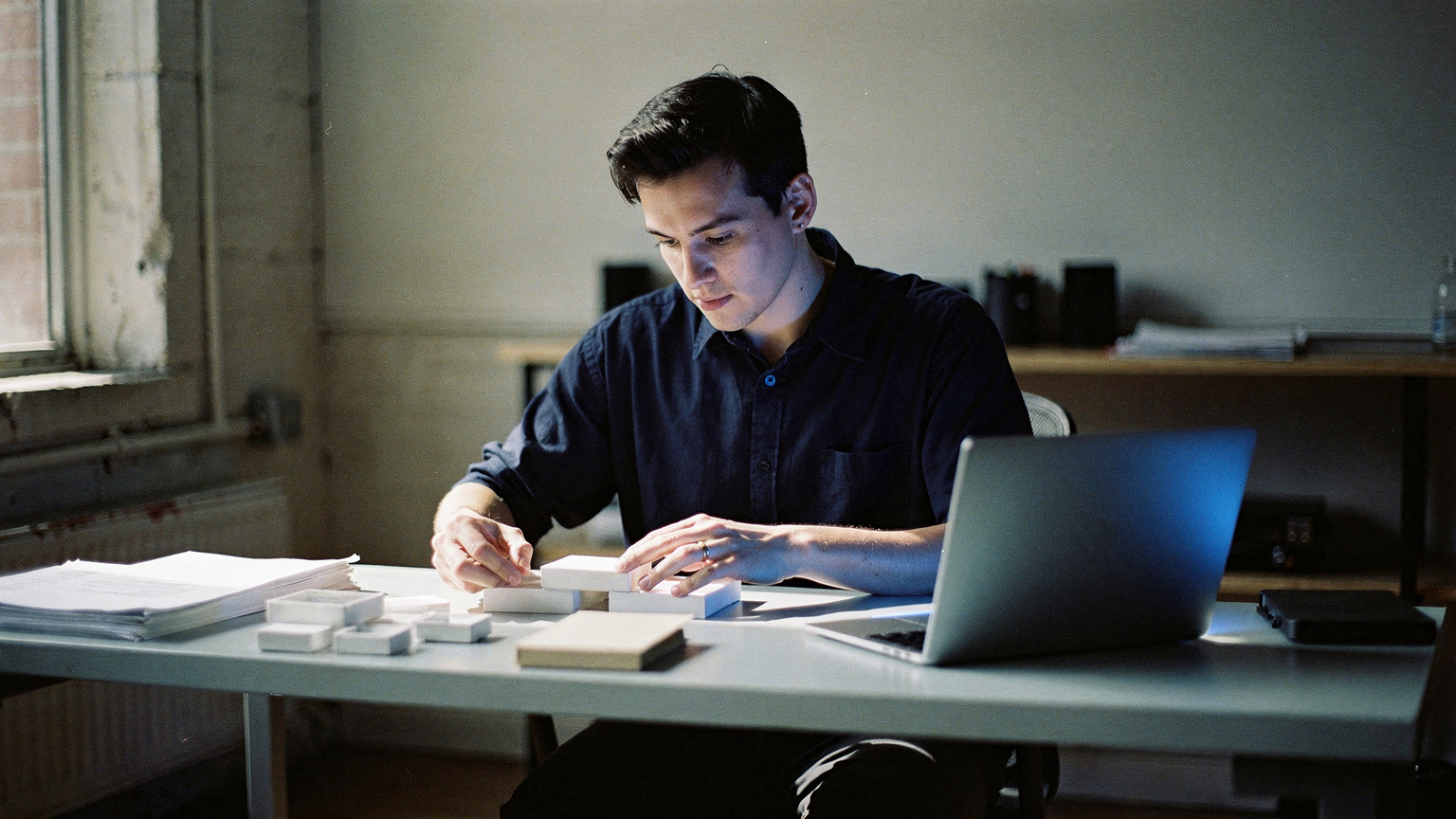 A catalog manager organizing detailed product information at a desk in a Brooklyn studio