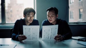 Two analysts comparing total cost of ownership figures on paper in a Brooklyn office