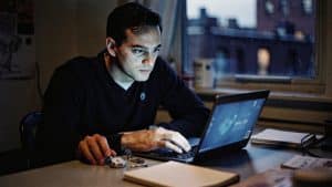 An engineer diagnosing a Magento performance problem with a stopwatch and notebook in a Brooklyn studio